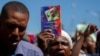 A protester holds up a copy of the Haitian Constitution during a protest to demand the resignation of Haiti's president Jovenel Moise in Port-au-Prince, Haiti, Feb. 10, 2021.