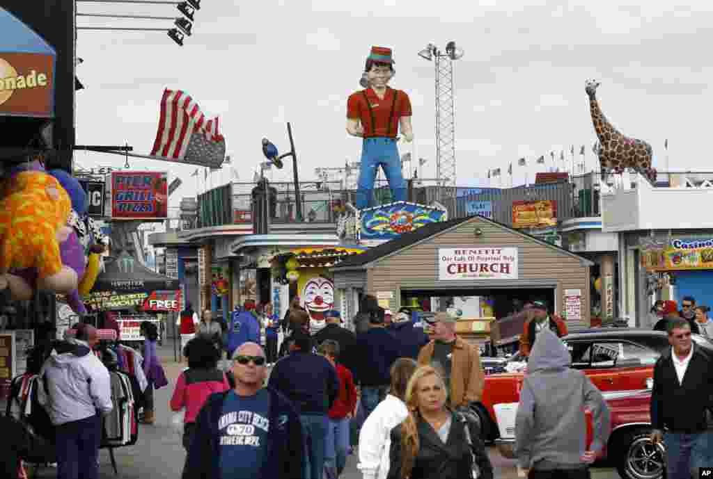People walk along a rebuilt portion of boardwalk a year afer it was destroyed by Superstorm Sandy, Seaside Heights, New Jersey, Oct. 13, 2013.