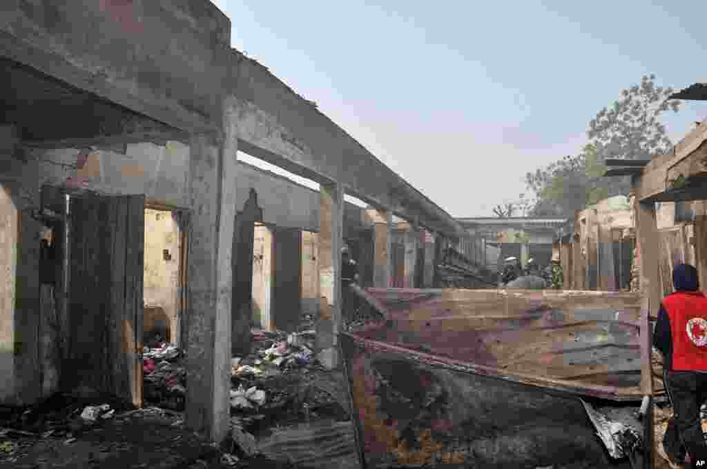 Des personnes inspectent des magasins endommagés par l'explosion d'une bombe lundi sur un marché de Bauchi, au Nigeria.