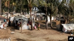 Muslim refugees stand near their tents in Awetawgyi refugee camp in Sittwe, Rakhine State, western Burma, January 8, 2013.