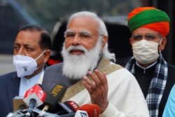 India's Prime Minister Narendra Modi speaks with the media as he arrives at the parliament house to attend the first day of the budget session, in New Delhi, India, Jan. 29, 2021.