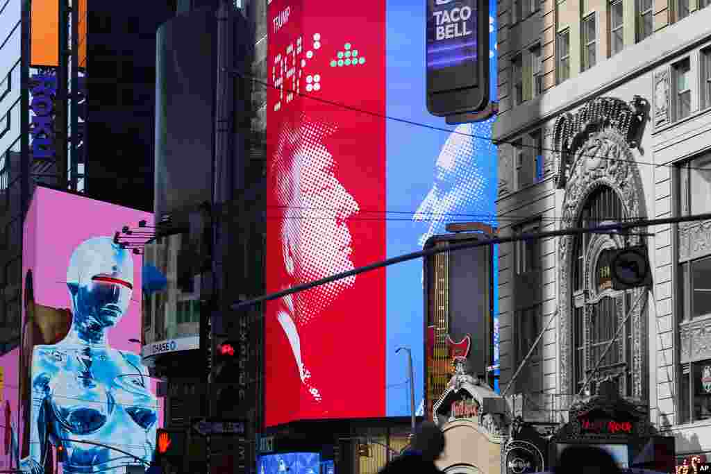 Images of Donald Trump and Kamala Harris are displayed on screens in Times Square in New York, Nov. 6, 2024. 