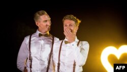 Australian Commonwealth Games sprinter Craig Burns, left, and fiance Luke Sullivan pose ahead of their marriage ceremony at Summergrove Estate, New South Wales, Jan. 8, 2018.