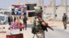 Des membres des forces russes et syriennes montent la garde au point de passage d'Abu Duhur, à l'est de la province d'Idlib, le 20 août 2018.