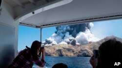 FILE - In this Dec. 9, 2019, photo provided by Michael Schade, tourists on a boat look at the volcanic eruption that killed 22 people on White Island, New Zealand. On Oct. 31, 2023, the company that managed the island was found guilty of failing to protect visitors. 