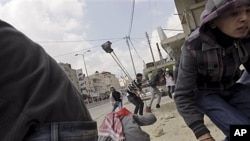 Palestinians throw stones at Israeli troops, Kalandia checkpoint between Jerusalem, Ramallah, March 30, 2012.