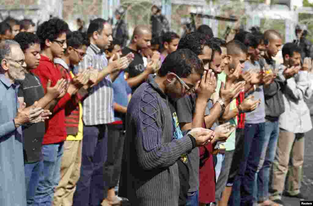 Supporters of the Muslim Brotherhood and ousted Egyptian President Mohamed Morsi pray outside the police academy, where Morsi's trial took place, on the outskirts of Cairo, Nov. 4, 2013.