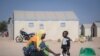 FILE - In this photo taken on Dec. 10, 2019 a displaced Burkinabe woman and child prepare food, in the Pissila town camp, near Kaya, Burkina Faso. 