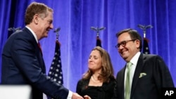 Wakil Perdagangan AS Robert Lightizer, kiri, berjabatan tangan dengan Menteri Ekonomi Meksiko, Ildefonso Guajardo Villareal, didampingi oleh Menlu Kanada Chrystia Freeland, setelah menghadiri konferensi pers di awal Perjanjian Ulang NAFTA di Washington 16 Agustus 2017 (foto: AP Photo/Jacquelyn Martin)