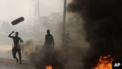 Matasa a fusace su na kona tayoyi da tarkace domin su nuna rashin yardarsu da janye tallafin farashin mai da gwamnatin shugaba Goodluck Jonathan ta yi, Lagos Talata, 10 Janairu 2012.