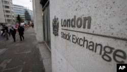 File - People walk past London's Stock Exchange, in London's City financial district, Nov. 3, 2011.
