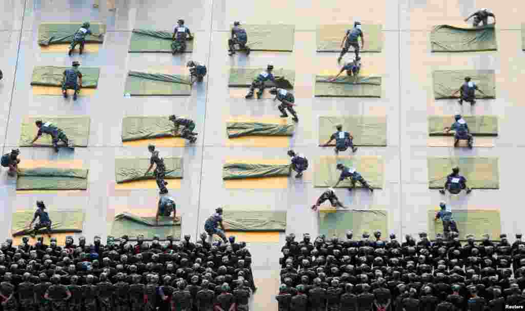University students participate in a competition of quilt-folding during military training at the start of a new semester in Hengyang, Hunan Province, China.