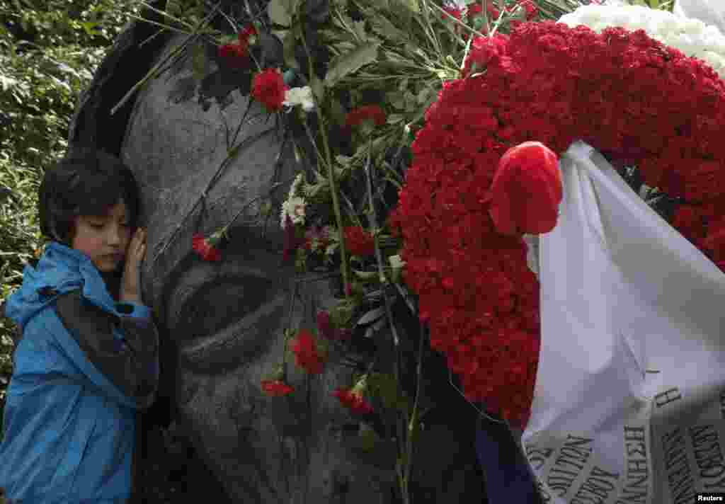A boy touches a monument inside the Athens' Polytechnic school, two days before the anniversary of a 1973 student uprising against the then military ruling junta in Athens, Greece.