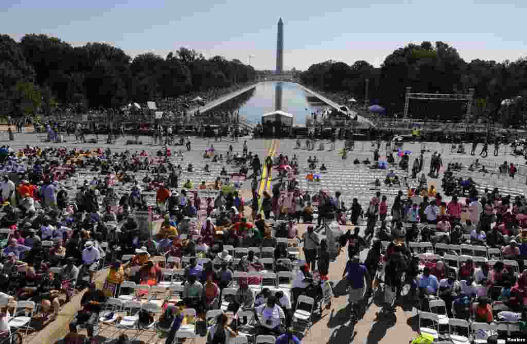 Crowds line the Reflecting Pool to watch the 50th anniversary ceremony of the 1963 March on Washington ceremony, with the Washington Monument in the backround, Aug. 24, 2013.