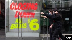 澳大利亚墨尔本商业区的行人走过关闭的商店。（2020年8月3日）