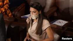 U.S. Rep. Alexandria Ocasio-Cortez (D-NY) talks with colleagues on the floor of the House Chamber as members of congress gathered to take their oath of office during the first session of the 117th Congress on Capitol Hill in Washington, Jan. 3, 2021.