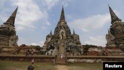 FILE - Tourists walk at the ruins of the ancient capital of Ayutthaya, Thailand, Dec. 25, 2015. International tourist arrivals in Thailand are expected to reach a record high in 2016, the tourism minister said on Jan. 6, 2016, after nearly 30 million foreigners came to its temples, beaches and bars in 2015. 