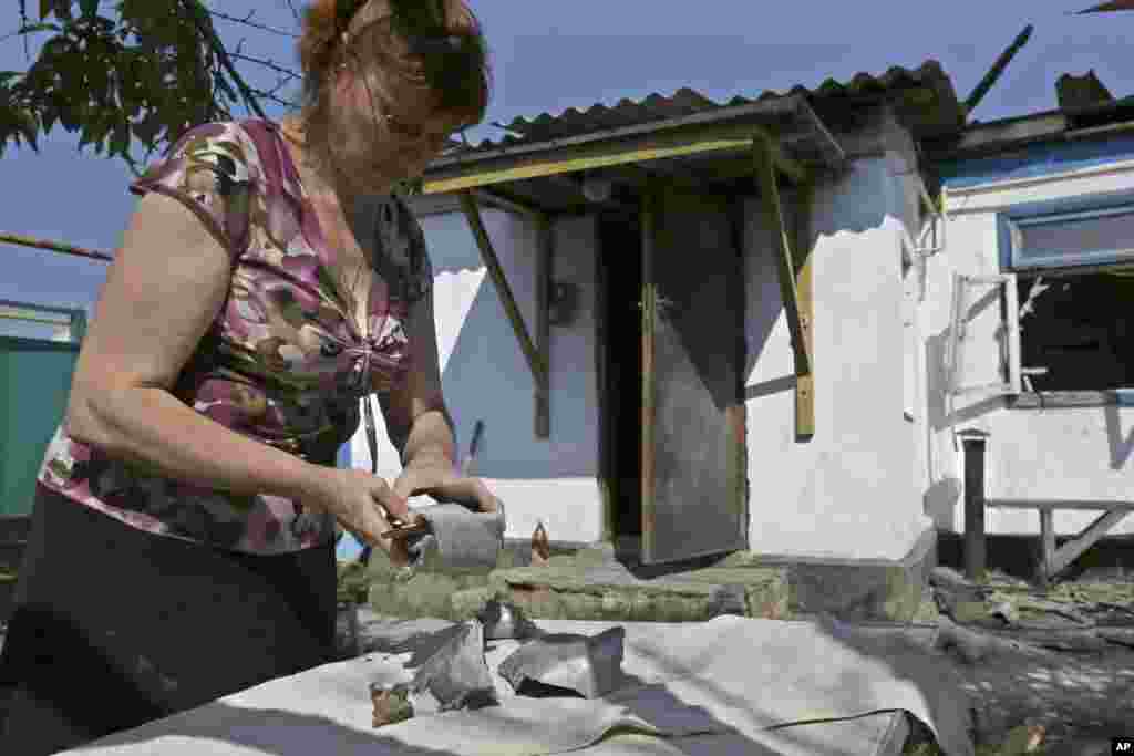 Local resident Svetlana Avdyukhin displays large fragments of a shell, in Donetsk, eastern Ukraine, Aug. 14, 2014.