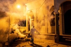 FILE - A municipal worker sprays disinfectant in a mosque to help curb the spread of the new coronavirus in Dakar, Senegal, April 1, 2020.