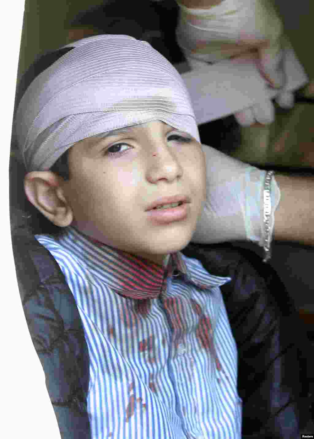 An injured school boy receives treatment inside an ambulance at the site of an explosion near the Iranian cultural centre in the southern suburbs of Beirut, Feb. 19, 2014. 