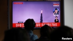 Orang-orang menonton rekaman file siaran TV dari laporan berita tentang Korea Utara yang menembakkan rudal balistik di lepas pantai timurnya, di Seoul, Korea Selatan, 19 Oktober 2021. (Foto: REUTERS/Kim Hong-Ji)