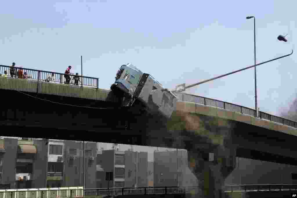 A police vehicle is pushed off of the 6th of October bridge by protesters close to the largest sit-in by supporters of ousted Islamist President Mohammed Morsi in the eastern Nasr City district of Cairo, Egypt, August 14, 2013.