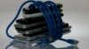 Foto ilustrasi ponsel-ponsel pintar yang dililit kabel jaringan internet, 7 Juni 20213. (Foto: Reuters)