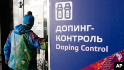 Seorang pria berjalan melewati papan bertuliskan "Doping Control" di lokasi Olimpiade Musim Dingin 2014 di Krasnaya Polyana, Socci, Rusia, 21 Februari 2014. (Foto: dok).