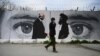 Un mur peint montrant Zalmay Khalilzad (g) le représentant spécial des États-Unis pour la réconciliation en Afghanistan et le cofondateur des talibans, Mullah Abdul Ghani Baradar, à Kaboul, le 5 avril 2020.