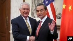 Poignée de main entre le ministre chinois des Affaires étrangères Wang Yi et le secrétaire d'État américain Rex Tillerson avant une réunion bilatérale au Diaoyutai State Guesthouse à Pékin, Chine, le 18 mars 2017.