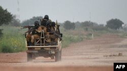 FILE - Burkinabe gendarmes patrol near military barracks in Ouagadougou, Sept. 29, 2015. Burkina Faso security forces launched a massive manhunt on April 27, 2021, after an attack on an anti-poaching patrol.