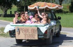 Six women cool themselves in water in a pick-up truck, which they sealed with a plastic sheet, in Unlingen, southern Germany, June 30, 2019.