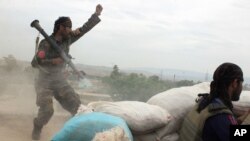 FILE - An Afghan National Army soldier shouts after firing a rocket toward Taliban positions on the outskirts of Kunduz, northern Afghanistan, April 16, 2016.