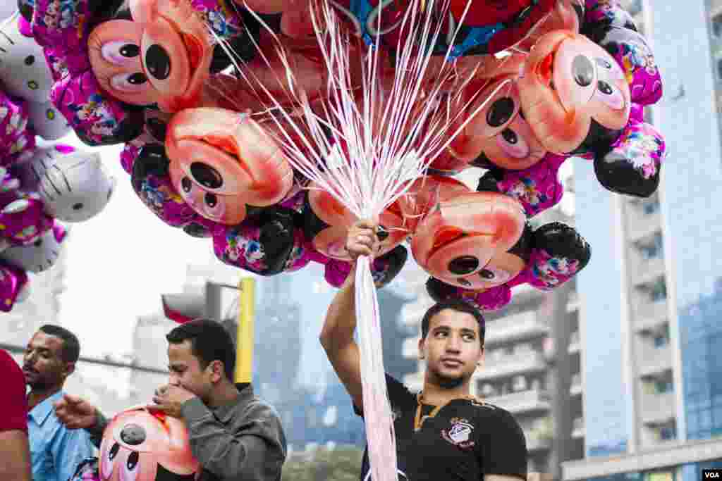Nader (28 tahun), seorang penjaja balon mengatakan, "Saya sudah jualan balon selama 10 tahun, dan saat Idul Fitri adalah musim yang terbaik", di lapangan Mostafa Mahmoud, Kairo, Mesir. 