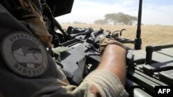 FILE - A soldier of France's Barkhane mission holds a weapon as he patrols in central Mali, in the border zone with Burkina Faso and Niger, Nov. 01, 2017.