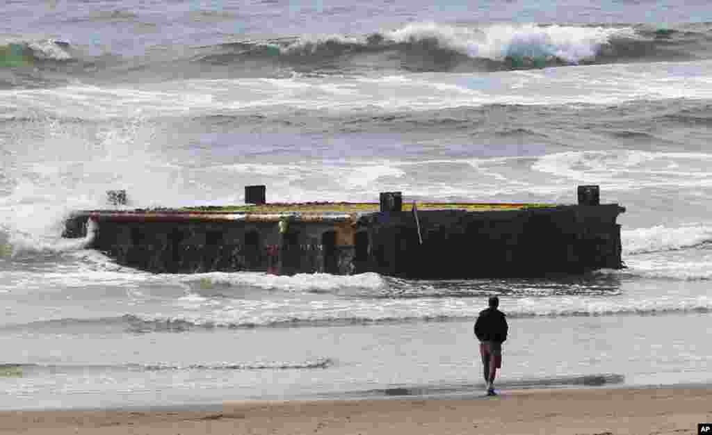 A man looks at the massive dock that washed ashore on Agate Beach on June 5, 2012, in Newport, Oregon.