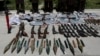 Weapons and ammunition seized are presented to the media along with insurgents suspected of being from the Haqqani network at the National Directorate of Security (NDS) headquarters in Kabul, May 30, 2013. 