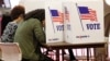 FILE - Voters fill out their ballots in the kiosks in Jackson, Miss., March 10, 2020.