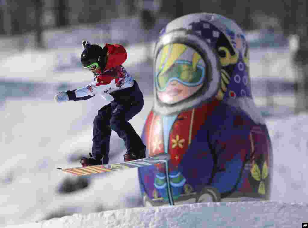Seorang kompetitor melompati boneka matryoshka raksasa pada latihan Snowboard Slopestyle di Rosa Khutor Extreme Park, menjelang Olimpiade Musim Dingin 2014, 4 Februari 2014.