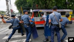 Polisi memukul para demonstran yang kabur saat terjadi kekerasaan saat berunjuk rasa di luar Kedutaan Besar Amerika Serikat di Manila, Filipina (19/10).