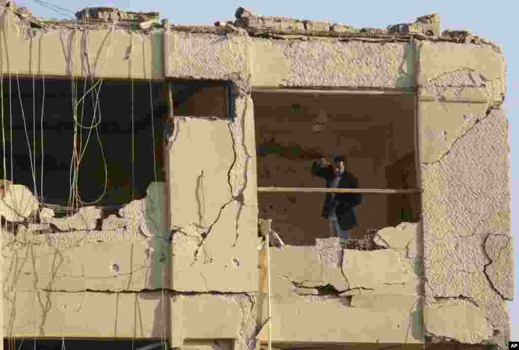 An Egyptian plainclothes policeman stands in the damaged national security building after a bomb exploded in the Shubra el-Kheima neighborhood of Cairo, injuring several people according to Egyptian security officials, early Aug. 20, 2015.