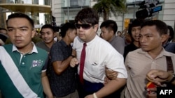 Thai policemen arrest an anti-coup protester (C) during a demonstration at a shopping mall in Bangkok, June 22, 2014. 