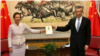 Caroline Wilson posted a picture of herself with China's ambassador to the U.K., Liu Xiaoming, in which they hold a copy of Xi Jinping's book "The Governance of China." (Caroline Wilson/Twitter)