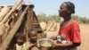 Toharano, une mère de 18 enfants se tient avec deux d'entre eux dans le village d'Ankilimarovahatsy, à Madagascar, le 9 novembre 2020.