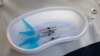 Syringes and a vial of AstraZeneca vaccine against COVID-19 sit on a general practitioners' table during a vaccination campaign in Amsterdam, Netherlands, Wednesday, April 14, 2021. (AP Photo/Peter Dejong)