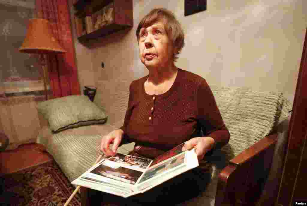 Varvara Tolokonnikova, grandmother of Nadezhda Tolokonnikova, shows family photos of Nadezhda at her apartment, as she waited for her granddaughter's release from prison, Dec. 21, 2013. 