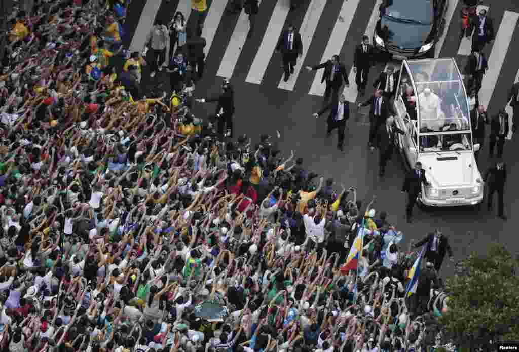 Pope Francis greets the crowd of faithful from his popemobile in downtown Rio de Janeiro, July 22, 2013.