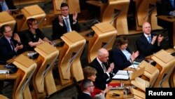 Scottish National Party lawmakers applaud after the vote on a second independence referendum in the Parliament in Holyrood, Edinburgh, March 28, 2017.