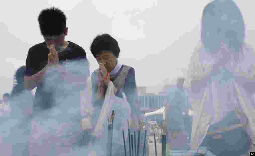 People pray for the atomic bomb victims at the Hiroshima Peace Memorial Park in Hiroshima, August 6, 2013.