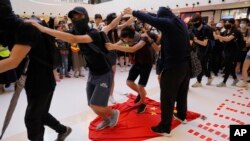 Para pengunjuk rasa menginjak bendera China dalam unjuk rasa di sebuah mall di Hong Kong, 22 September 2019. 
